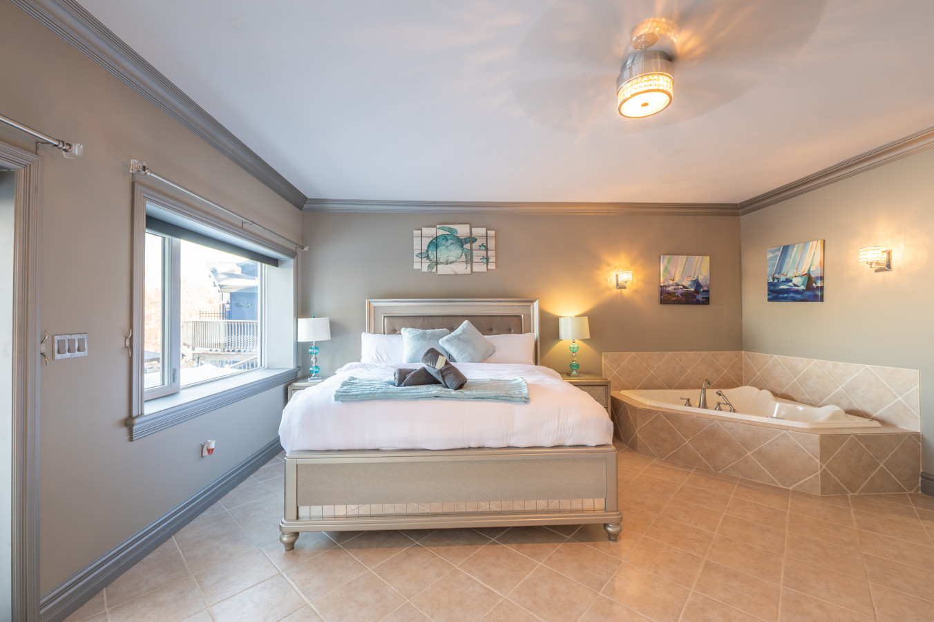 white bed with towels on it and a grey room with bay doors